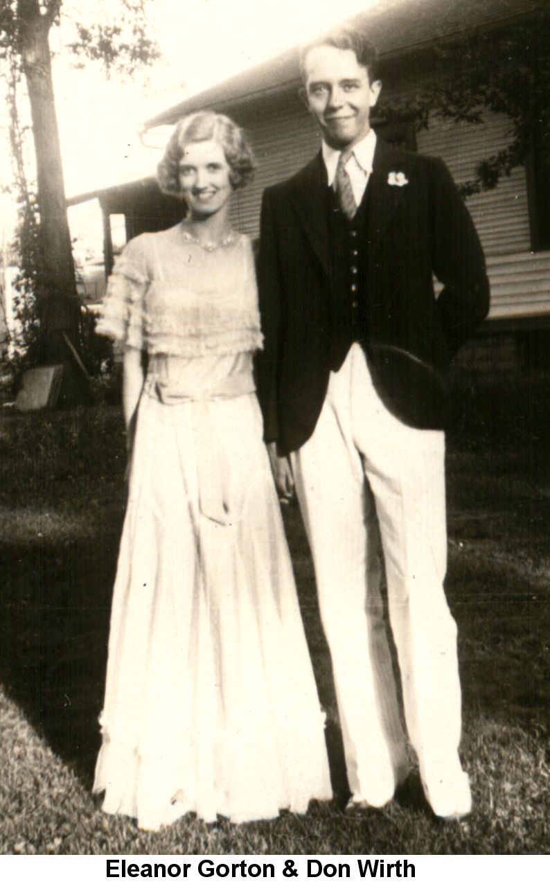 Black and white photo of Eleanor Gorton with blond flat-curled hair, wearing a floor-length white dress with a frilly top, standing close to Donald Wirth, wearing a black cutaway jacket and white pants, standing before a frame house and tall tree.